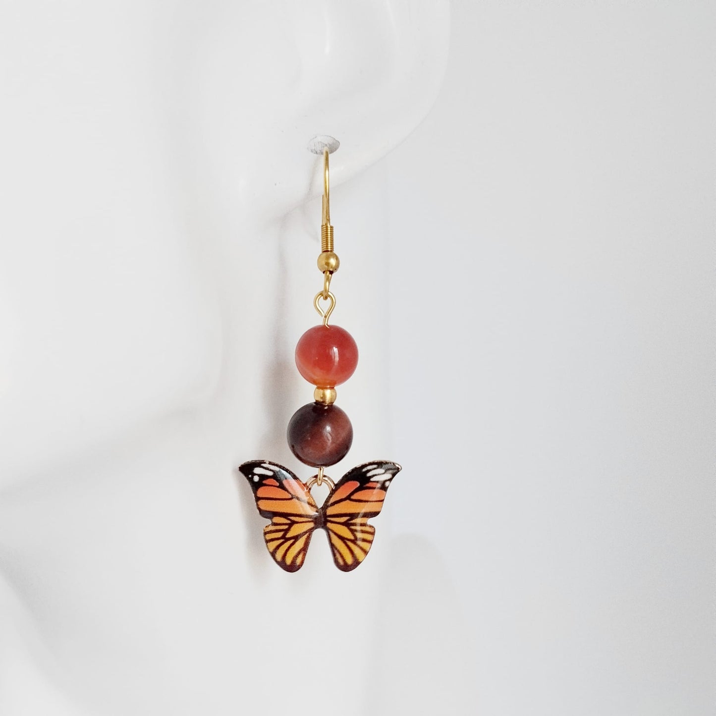 Bijou en Cornaline et Œil de Taureau pour la vitalité et l'ancrage. Profitez d'une protection puissante avec ce bijou papillon. Découvrez la collection !