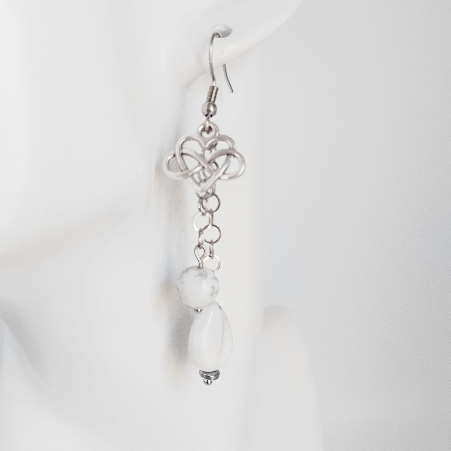 Découvrez nos boucles d'oreilles en Howlite véritable, ornées du symbole infini cœur. Un bijou artisanal unique pour célébrer l'amour éternel et la sérénité.