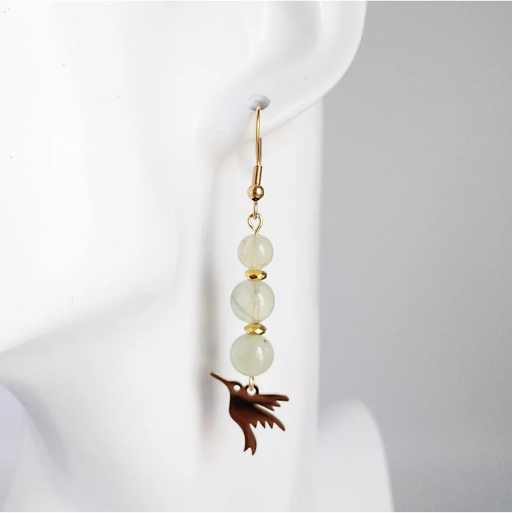 Craquez pour nos boucles d’oreilles en Préhnite naturelle, une pierre apaisante et protectrice qui favorise le calme, la clarté et la sérénité.
