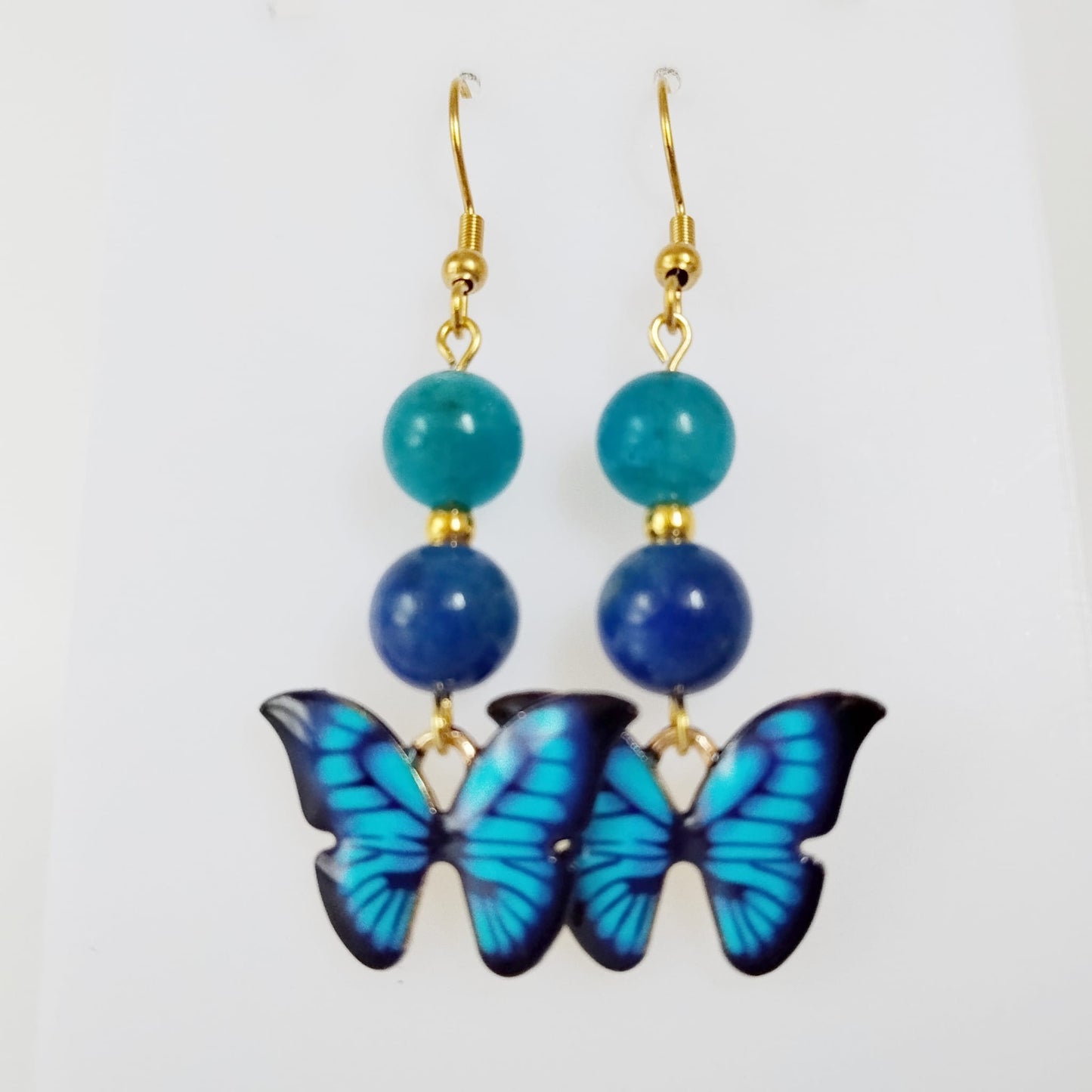 Boucles d’oreilles en Apatite AAA et Lapis Lazuli AA avec symbole papillon. Bijoux énergétiques pour l’expression, la confiance et la transformation intérieure. Élégance et puissance au quotidien.
