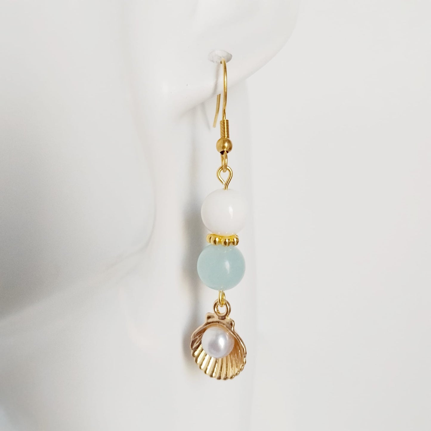 Découvrez les boucles d'oreilles en Aigue-Marine, Nacre et Saint-Jacques. Des bijoux sacrés en acier inoxydable pour illuminer le visage et apaiser l'esprit.
