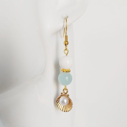 Découvrez les boucles d'oreilles en Aigue-Marine, Nacre et Saint-Jacques. Des bijoux sacrés en acier inoxydable pour illuminer le visage et apaiser l'esprit.