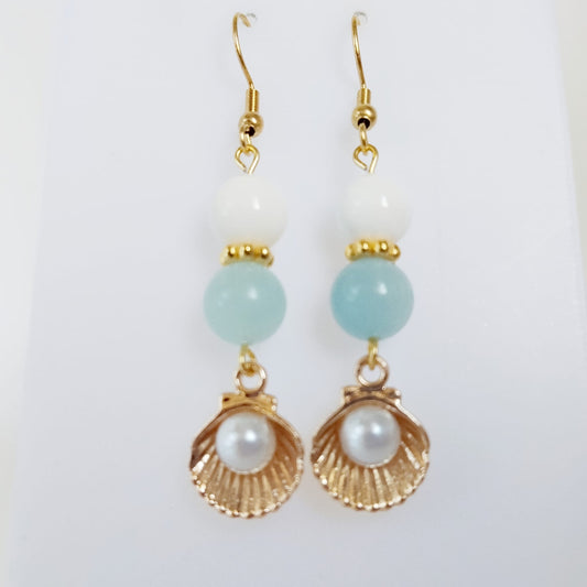 Découvrez les boucles d'oreilles en Aigue-Marine, Nacre et Saint-Jacques. Des bijoux sacrés en acier inoxydable pour illuminer le visage et apaiser l'esprit.