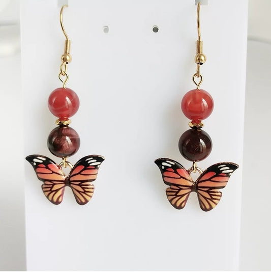 Boucles d'oreilles en pierres naturelles Cornaline & Œil de Taureau avec pendentif papillon – énergie, protection et ancrage. Un bijou spirituel pour vitalité, confiance et équilibre.
