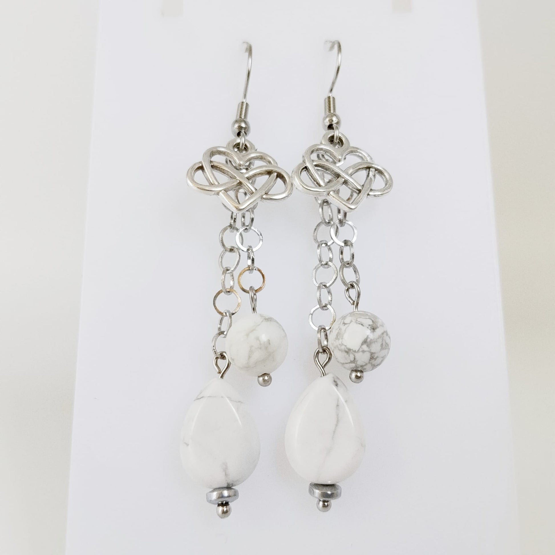 Découvrez nos boucles d'oreilles en Howlite véritable, ornées du symbole infini cœur. Un bijou artisanal unique pour célébrer l'amour éternel et la sérénité.