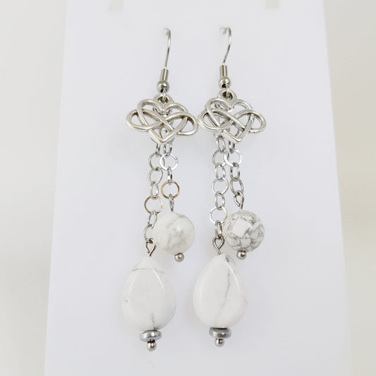 Découvrez nos boucles d'oreilles en Howlite véritable, ornées du symbole infini cœur. Un bijou artisanal unique pour célébrer l'amour éternel et la sérénité.