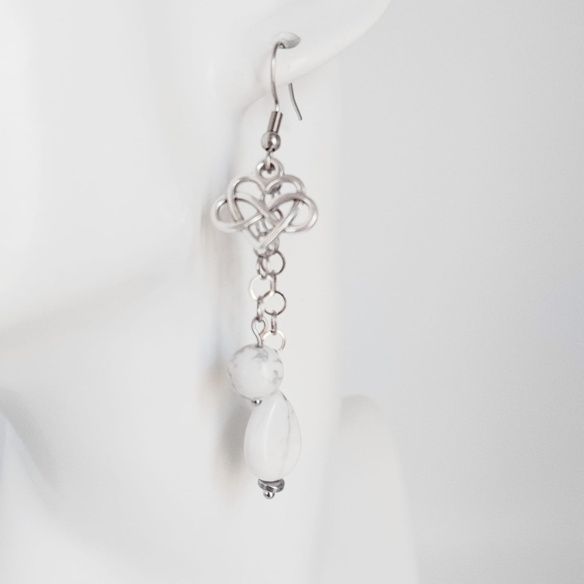 Découvrez nos boucles d'oreilles en Howlite véritable, ornées du symbole infini cœur. Un bijou artisanal unique pour célébrer l'amour éternel et la sérénité.