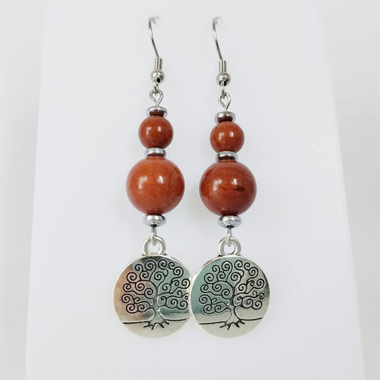 Craquez pour ces boucles d’oreilles en Jaspe Rouge naturel avec Arbre de Vie. Un bijou symbolique associé à l’ancrage, à la force intérieure et à la renaissance.