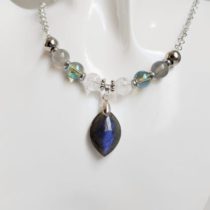 Découvrez le collier Protection & Sérénité en Labradorite AAA, Aqua Aura et Cristal de Roche. Désormais disponible en finitions Doré et Argenté. Équilibrez vos énergies et protégez votre aura avec ce bijou artisanal unique. Livraison rapide.