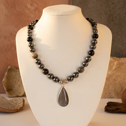 Collier en obsidienne argentée et hématite, pierres naturelles associées à la protection et à l’ancrage. Un bijou élégant et symbolique.
