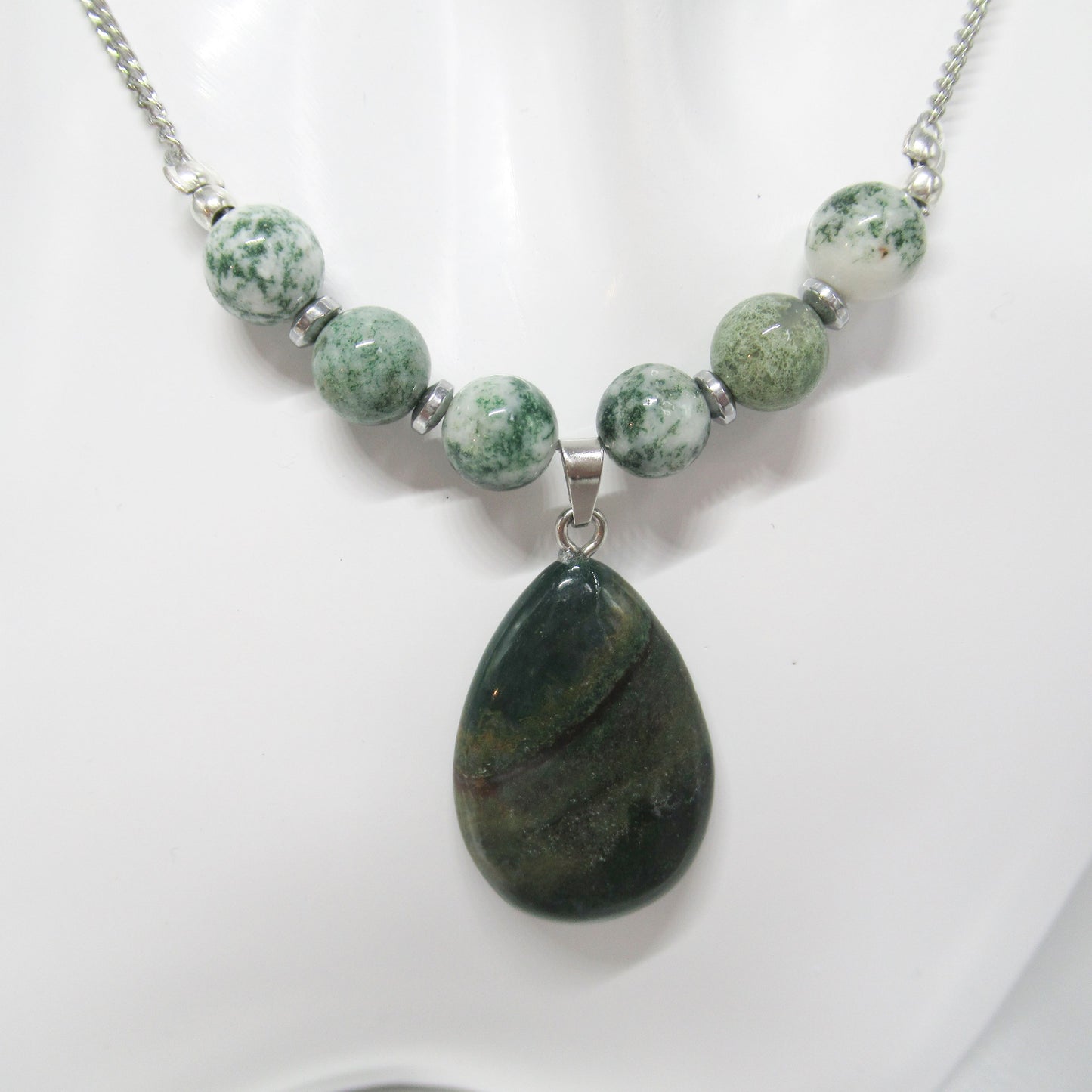 Collier Agate mousse - goutte  https://monjolicaillou.fr/products/collier-agate-mousse-goutte  Apportez une touche de nature et d'originalité à votre look avec ce bijou raffiné, conçu pour captiver les regards et refléter votre personnalité unique. Collier en acier inoxydable argenté, composé de 6 perles en Agate mousse. : taille +/- 30mm Taille des perles : Pendentif +/- 8mm Taille de la chaîne : +/- 45 cm Chaî