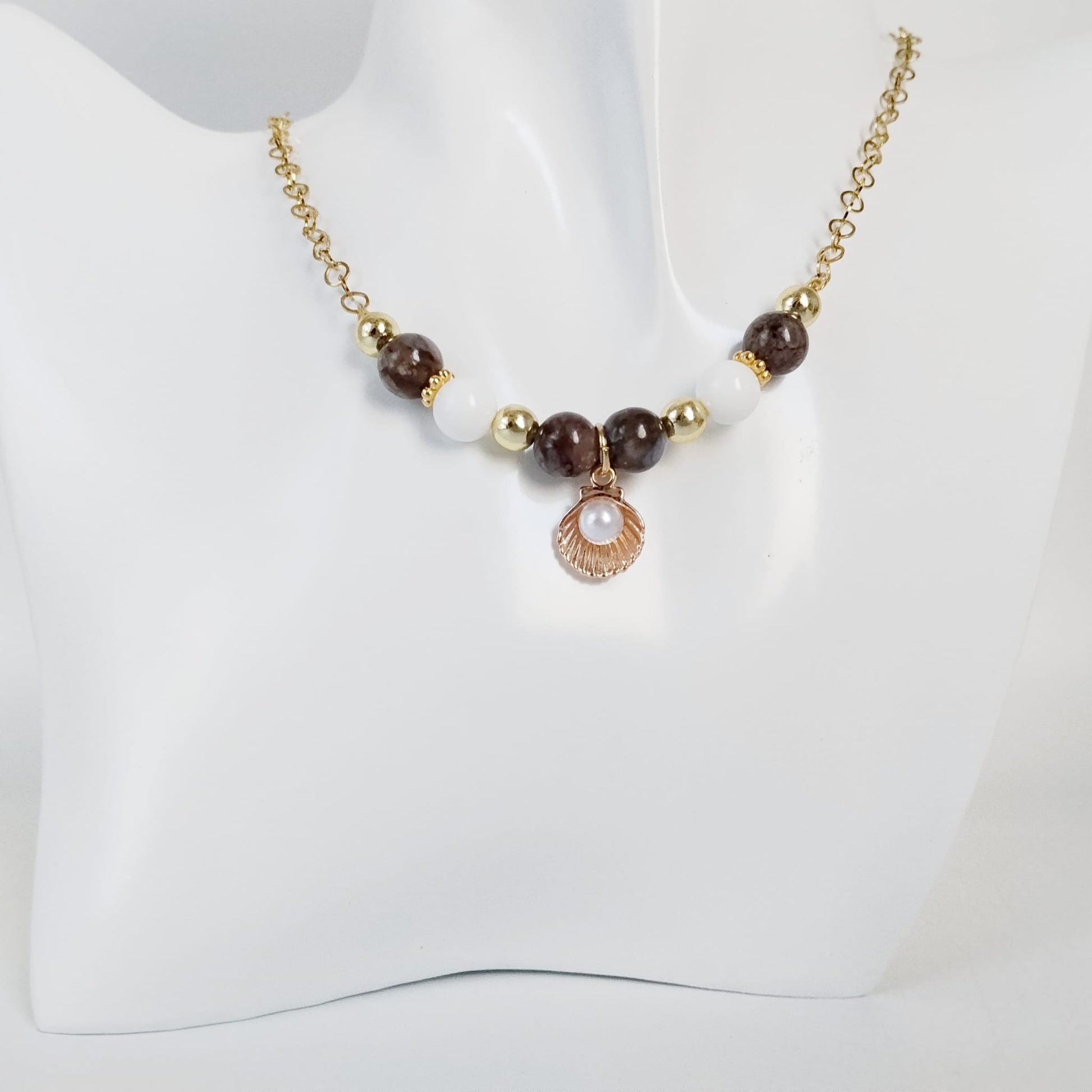 Découvrez le collier en Agate Turitelle, Nacre et pendentif Saint-Jacques. Un bijou artisanal unique alliant ancrage, douceur océanique et élégance en acier inoxydable.