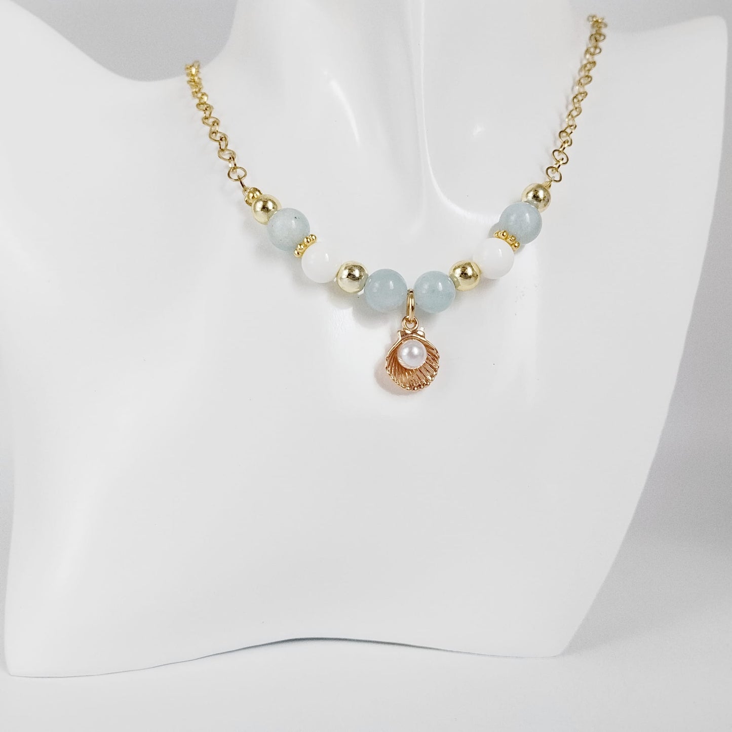 Découvrez le collier en Aigue-Marine, Nacre et son pendentif Saint-Jacques. Un bijou sacré alliant sérénité marine, communication fluide et haute protection vibratoire.