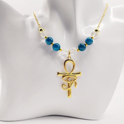 Collier en Apatite et Cristal de Roche avec pendentif Ankh et Œil d’Horus en acier inoxydable. Bijou spirituel favorisant communication, protection et harmonie énergétique.