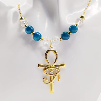 Collier en Apatite et Cristal de Roche avec pendentif Ankh et Œil d’Horus en acier inoxydable. Bijou spirituel favorisant communication, protection et harmonie énergétique.