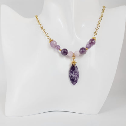 Découvrez ce collier doré exclusif mariant Lépidolite, Améthyste et Kunzite. Un bijou énergétique unique pour apaiser l'esprit, libérer le stress et sublimer votre aura au quotidien.