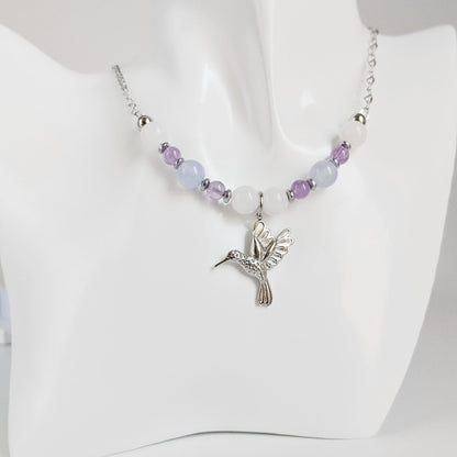 Découvrez notre collier Colibri en Jade blanc, Calcédoine et Améthyste. Un bijou artisanal en pierres naturelles synonyme de sérénité, clarté et douceur.