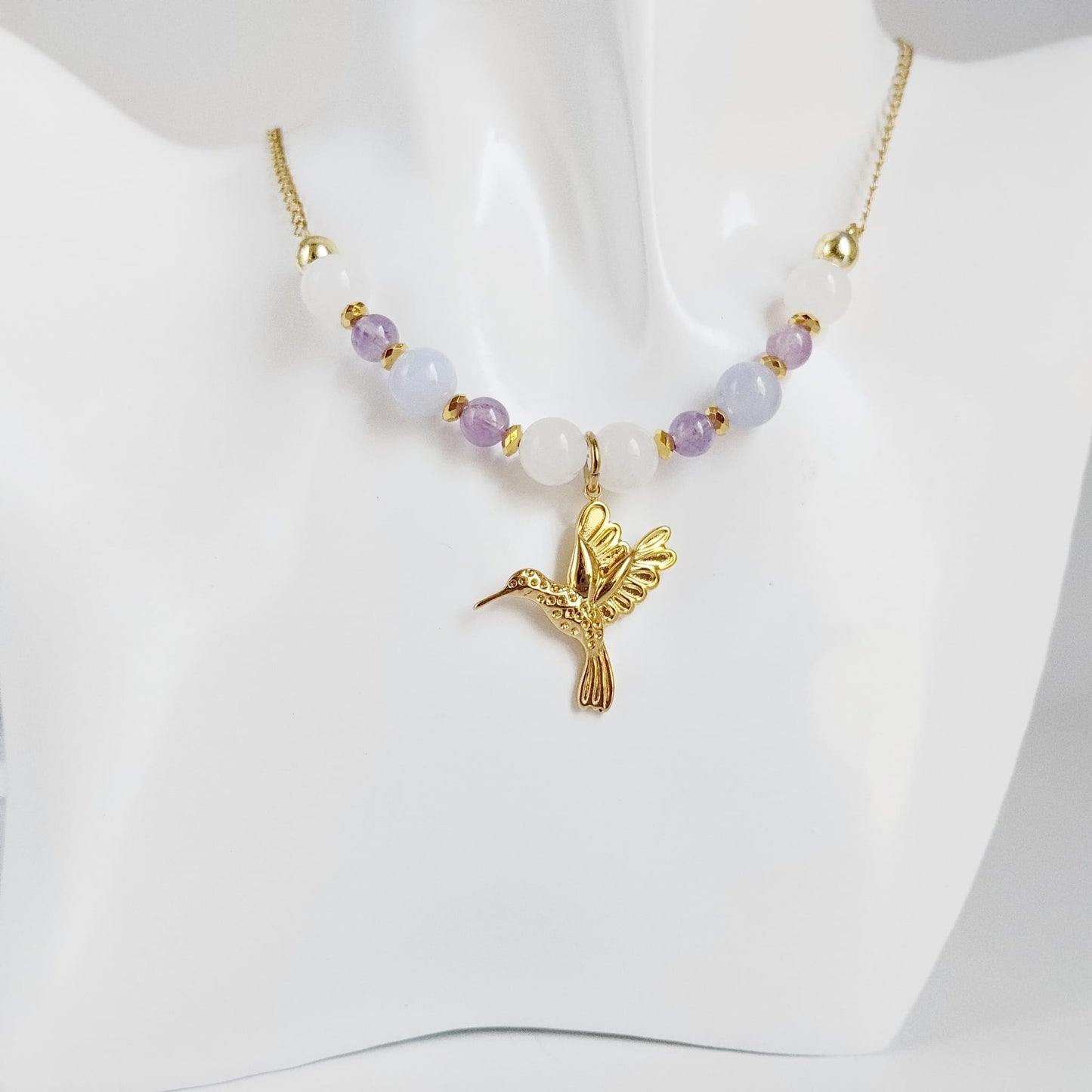 Découvrez notre collier Colibri en Jade blanc, Calcédoine et Améthyste. Un bijou artisanal en pierres naturelles synonyme de sérénité, clarté et douceur.