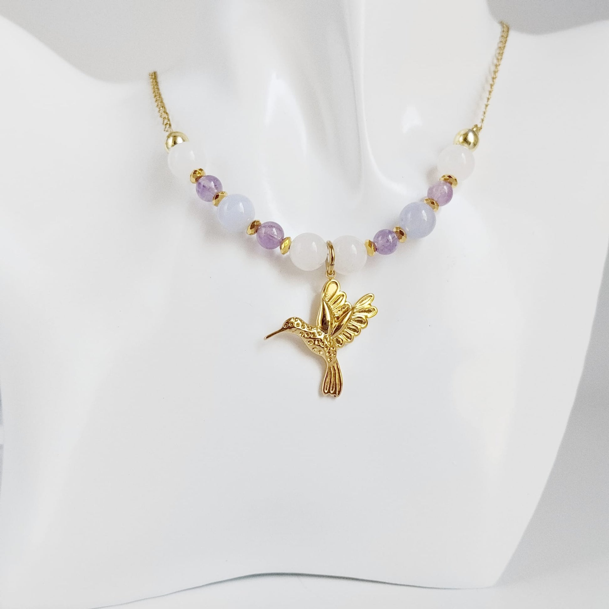 Découvrez notre collier Colibri en Jade blanc, Calcédoine et Améthyste. Un bijou artisanal en pierres naturelles synonyme de sérénité, clarté et douceur.