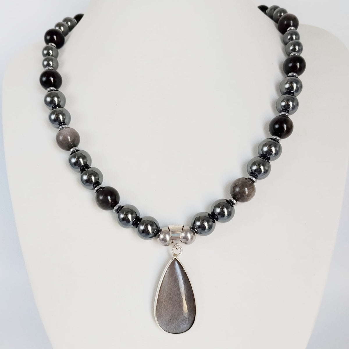 Collier en obsidienne argentée et hématite, pierres naturelles associées à la protection et à l’ancrage. Un bijou élégant et symbolique.