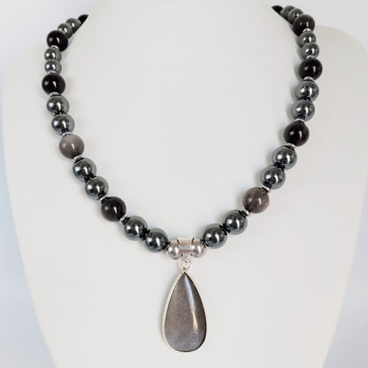 Collier en obsidienne argentée et hématite, pierres naturelles associées à la protection et à l’ancrage. Un bijou élégant et symbolique.