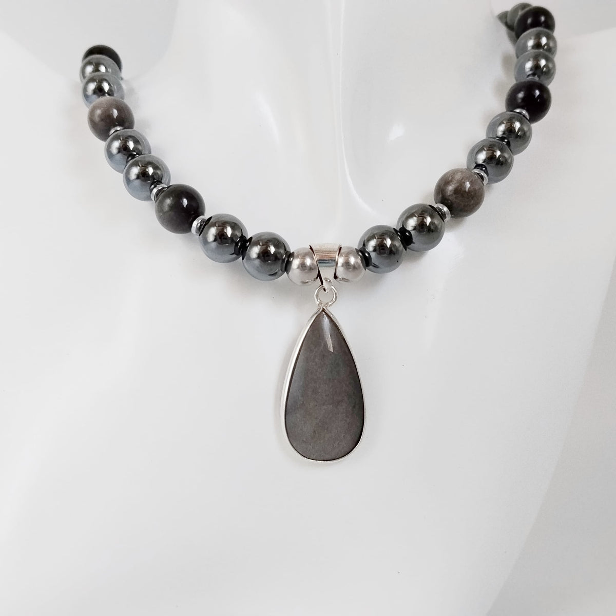 Collier en obsidienne argentée et hématite, pierres naturelles associées à la protection et à l’ancrage. Un bijou élégant et symbolique.