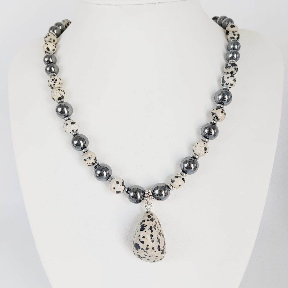 Parure Hématite & Jaspe Dalmatien en pierres naturelles : collier, bracelet ou boucles d’oreilles. Une association symbolique entre ancrage, équilibre et protection.