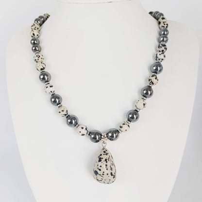 Parure Hématite & Jaspe Dalmatien en pierres naturelles : collier, bracelet ou boucles d’oreilles. Une association symbolique entre ancrage, équilibre et protection.