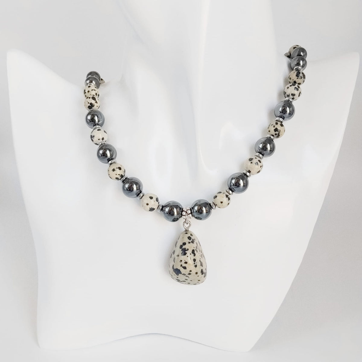 Parure Hématite & Jaspe Dalmatien en pierres naturelles : collier, bracelet ou boucles d’oreilles. Une association symbolique entre ancrage, équilibre et protection.