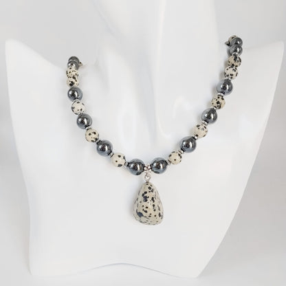 Parure Hématite & Jaspe Dalmatien en pierres naturelles : collier, bracelet ou boucles d’oreilles. Une association symbolique entre ancrage, équilibre et protection.