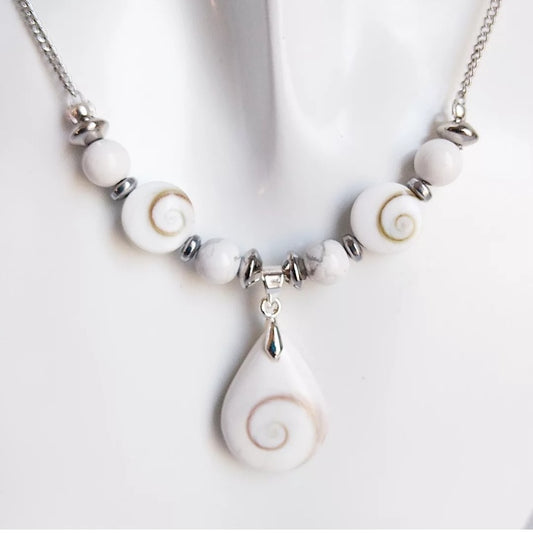 Collier argenté fait main avec Howlite et Œil de Sainte Lucie. Apaisement, protection et élégance réunis dans un bijou porte-bonheur au design raffiné.

