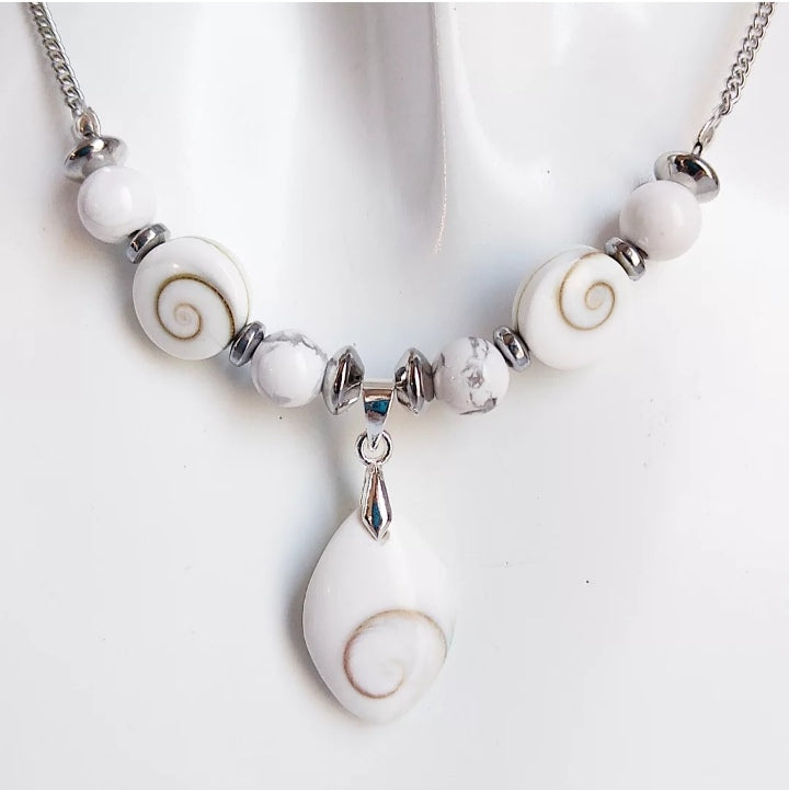 Collier argenté fait main avec Howlite et Œil de Sainte Lucie. Apaisement, protection et élégance réunis dans un bijou porte-bonheur au design raffiné.

