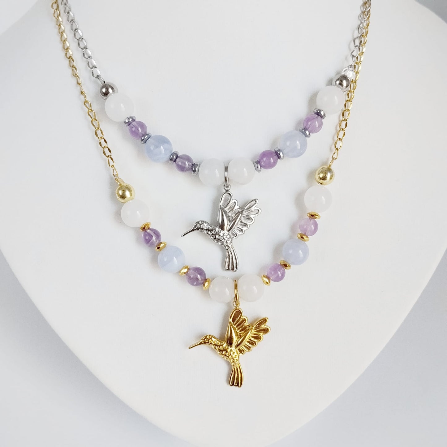 Découvrez notre collier Colibri en Jade blanc, Calcédoine et Améthyste. Un bijou artisanal en pierres naturelles synonyme de sérénité, clarté et douceur.