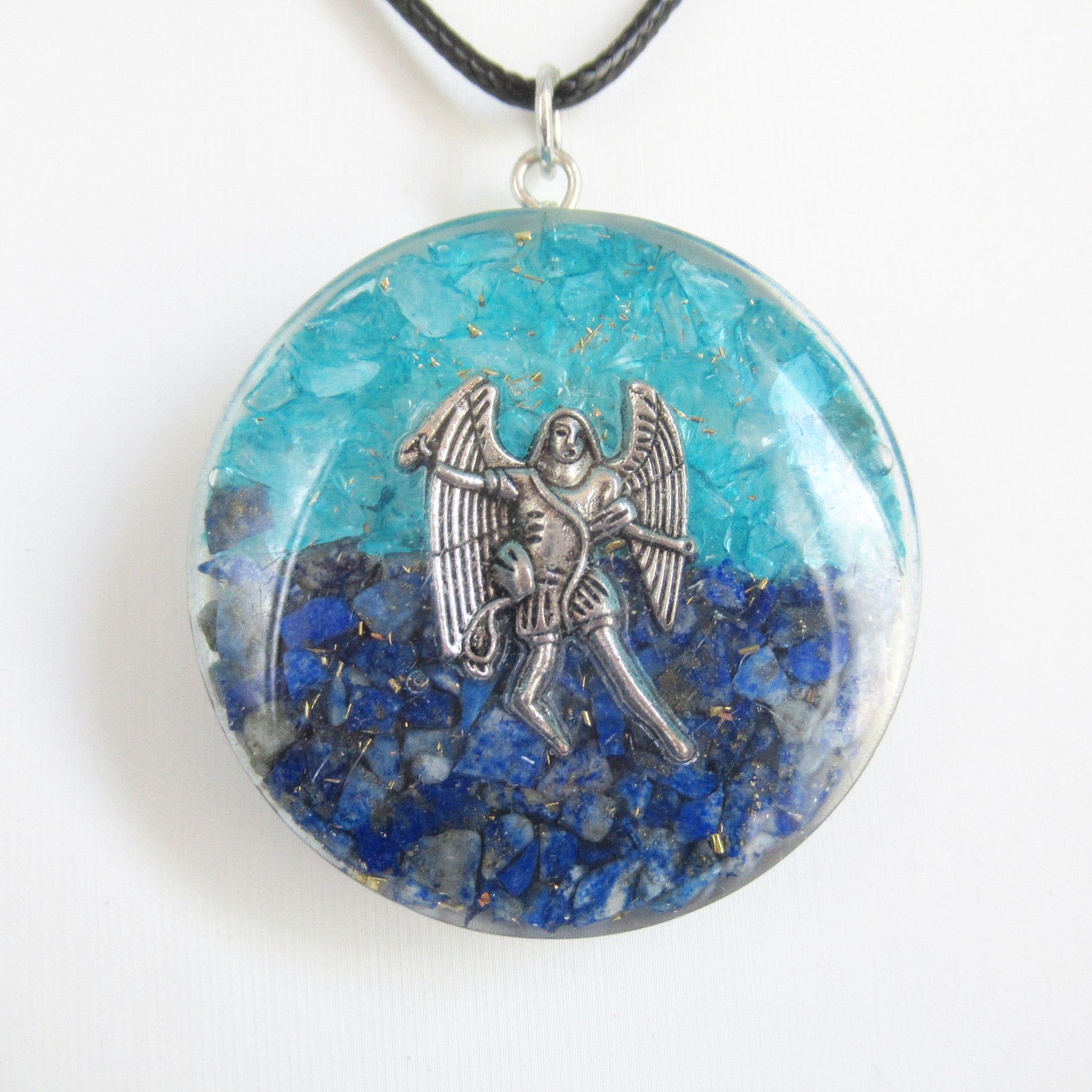 Pendentif Orgonite - Archange Saint Michel - 40 mm  https://monjolicaillou.fr/products/pendentif-orgonite-archange-saint-michel-40-mm  Découvrez ce magnifique pendentif en Orgonite, orné de Lapis-lazuli et de Topaze bleue, conçu pour restaurer votre énergie vitale, Chi, Prana et Ether. Ce bijou unique, contenant de la résine, des cristaux et du métal, équilibre votre aura. Pour activer ses puissantes propriétés, tenez-le simplement dans vos mains pendant