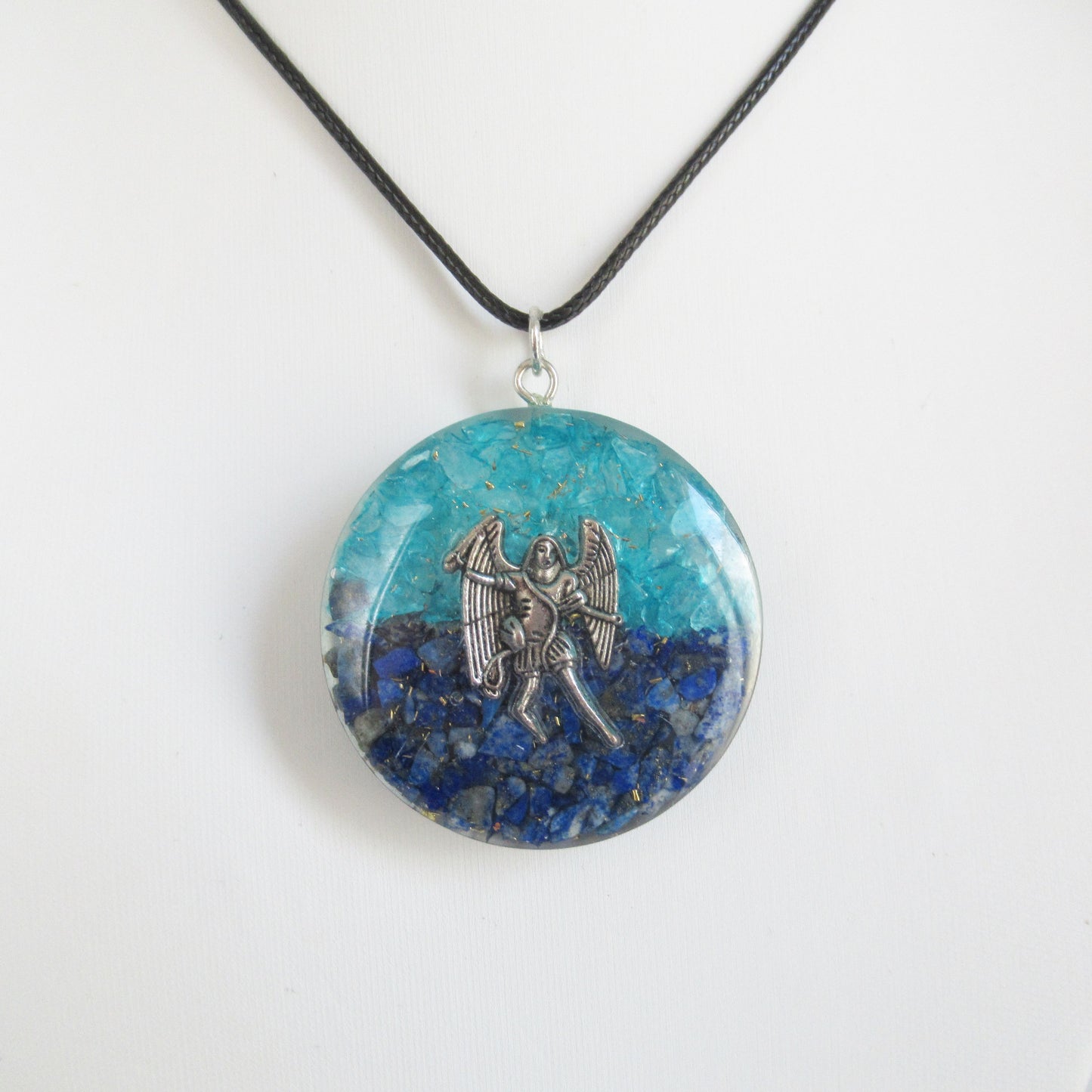 Pendentif Orgonite - Archange Saint Michel - 40 mm  https://monjolicaillou.fr/products/pendentif-orgonite-archange-saint-michel-40-mm  Découvrez ce magnifique pendentif en Orgonite, orné de Lapis-lazuli et de Topaze bleue, conçu pour restaurer votre énergie vitale, Chi, Prana et Ether. Ce bijou unique, contenant de la résine, des cristaux et du métal, équilibre votre aura. Pour activer ses puissantes propriétés, tenez-le simplement dans vos mains pendant