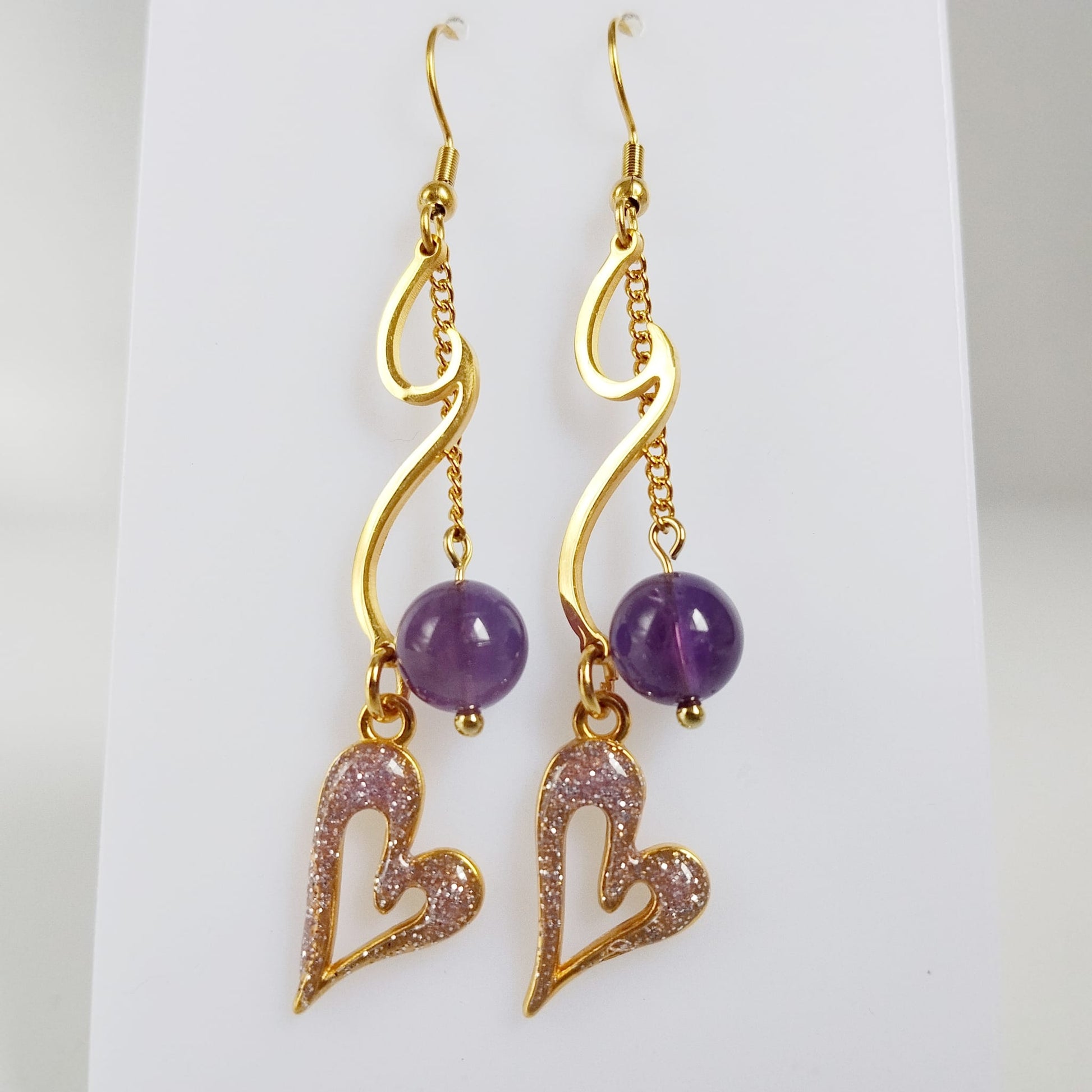 Découvrez les boucles d'oreilles vague en acier inoxydable doré et pierres naturelles. Laissez-vous envoûter par les énergies de l'Apatite, de l'Améthyste ou de la Malachite pour sublimer votre style et votre bien-être au quotidien.