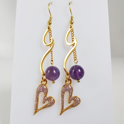Découvrez les boucles d'oreilles vague en acier inoxydable doré et pierres naturelles. Laissez-vous envoûter par les énergies de l'Apatite, de l'Améthyste ou de la Malachite pour sublimer votre style et votre bien-être au quotidien.
