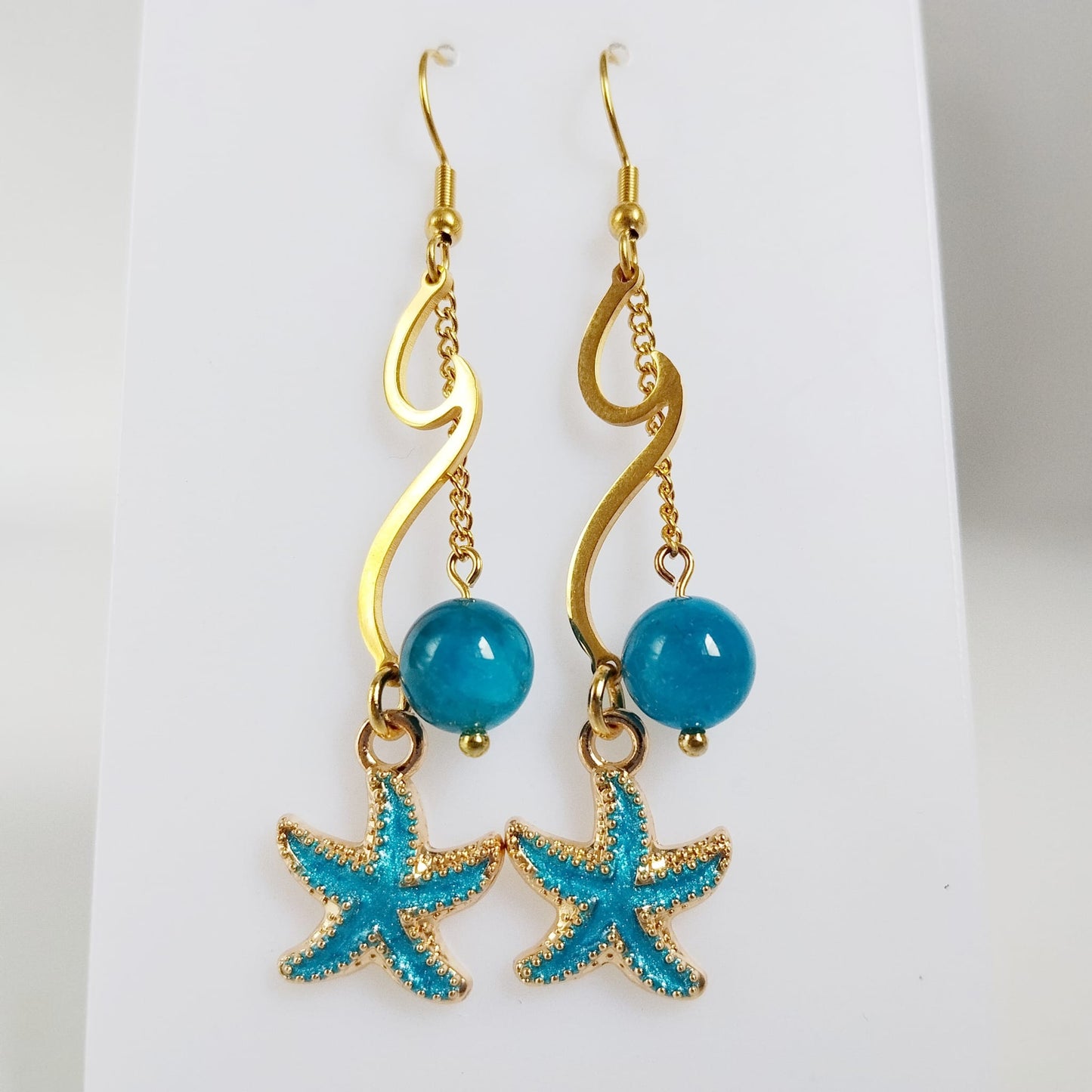 Découvrez les boucles d'oreilles vague en acier inoxydable doré et pierres naturelles. Laissez-vous envoûter par les énergies de l'Apatite, de l'Améthyste ou de la Malachite pour sublimer votre style et votre bien-être au quotidien.