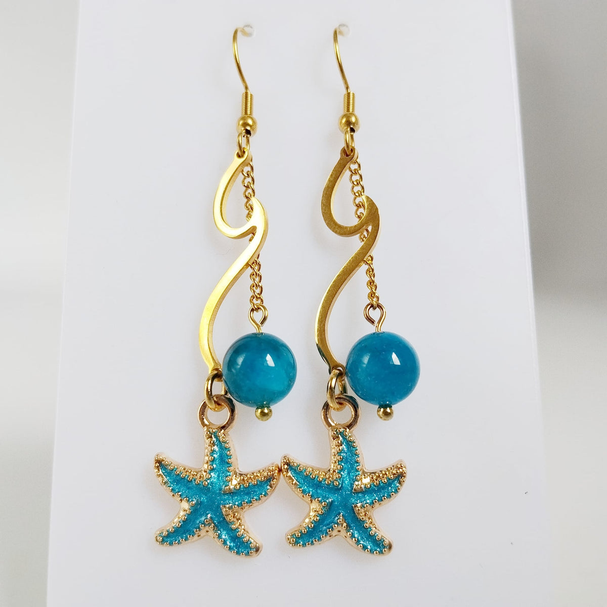 Découvrez les boucles d'oreilles vague en acier inoxydable doré et pierres naturelles. Laissez-vous envoûter par les énergies de l'Apatite, de l'Améthyste ou de la Malachite pour sublimer votre style et votre bien-être au quotidien.